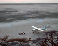 A light aircraft is parked on the edge of a granite island in the Makgadikgadi Pans in central Botswana