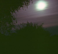A full moon glows from behind the clouds in the Chobe National Park in Botswana