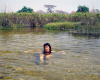 Clarissa Augustinus, wife of artist Paul Augustinus, swims at a pool just downstream of an Okavango mopane log bridge in Jau, Okavango, Botswana